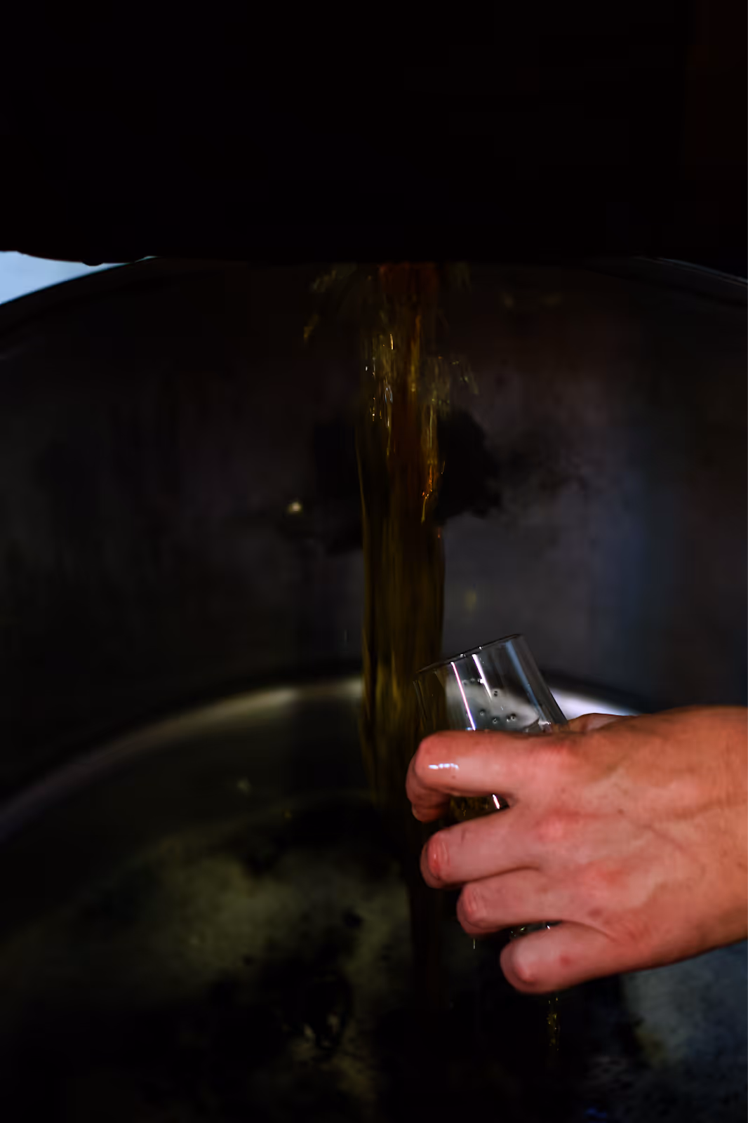 Distiller hand-inspecting a freshly filled American white oak barrel at the Luminance cooperage